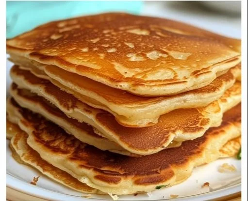 Panqueques caseros esponjosos y dorados servidos con sirope y frutas.